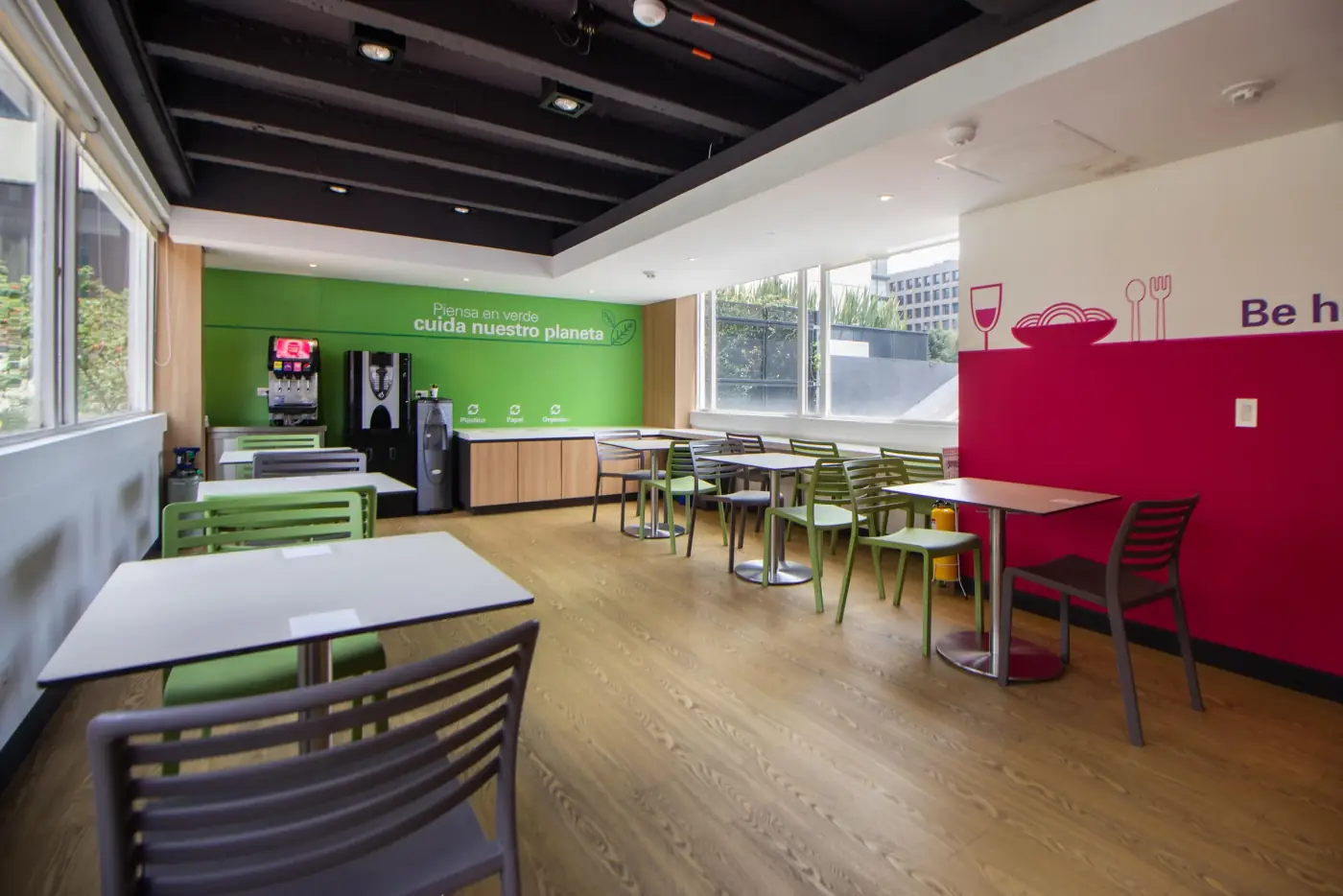 Comedor de empresa con mesas, sillas y máquinas de bebidas y café a disposición del personal